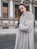 Side view of Sapphire Grey Mink Fur Coat S Petit Excellent, styled with red lipstick and black gloves for a bold winter look.