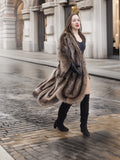 Canadian Raccoon Fur Coat in silver tips flowing while walking, styled with black boots for chic winter fashion.