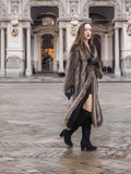 Model walking in Canadian Raccoon Fur Coat with silver tips, showcasing full-length fur and elegant winter fashion.