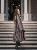 Back view of Canadian Raccoon Fur Coat in silver tips on stairs, highlighting full-length design and elegant winter outerwear.