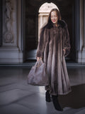 Woman in a fur coat holding a handbag in an elegant interior setting