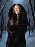 Woman in a black fur coat standing in a snowy forest