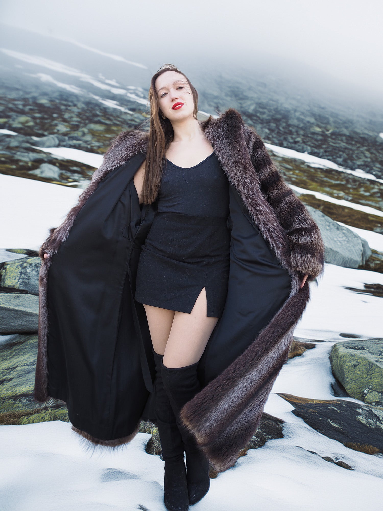Model showcasing Silver Tip Canadian Raccoon Fur Coat open over black dress. Stylish fur outerwear for winter elegance.