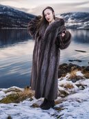 Full-length Silver Tip Canadian Raccoon Fur Coat in size M styled in snowy landscape. Elegant and warm luxury winter fashion.