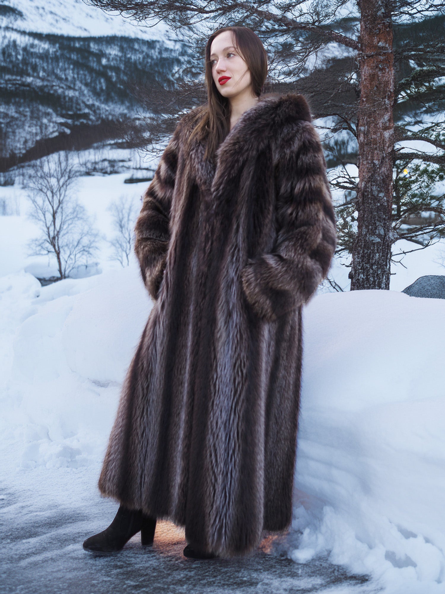 Silver Tip Canadian Raccoon Fur Coat styled in snowy forest. Warm and elegant full-length fur outerwear for winter.