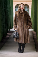 Fine mink coat with hooded neckline, long sleeves, straight front and swing length
