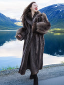 Model walking by lake in luxurious Canadian Raccoon Fur Coat, highlighting natural fur texture and elegant winter style.