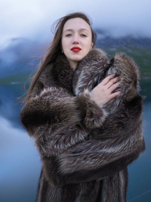 Close-up of woman wrapped in Canadian Raccoon Fur Coat, showcasing plush texture and natural fur elegance for winter.