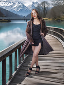 Woman in a fur coat standing on a wooden bridge with a mountainous landscape in the background