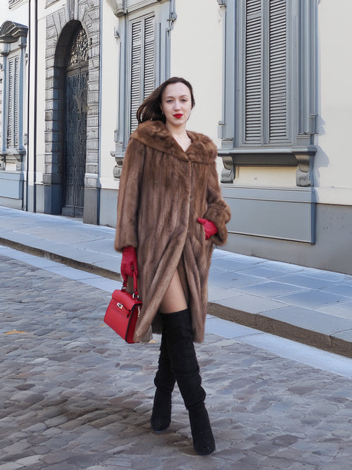 Vintage pastel Canadian brown mink fur coat styled with thigh-high boots and red gloves, offering a bold and elegant winter fashion look.