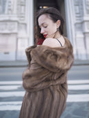 Close-up of vintage pastel Canadian brown mink fur coat draped off shoulder, highlighting luxurious texture and feminine silhouette.