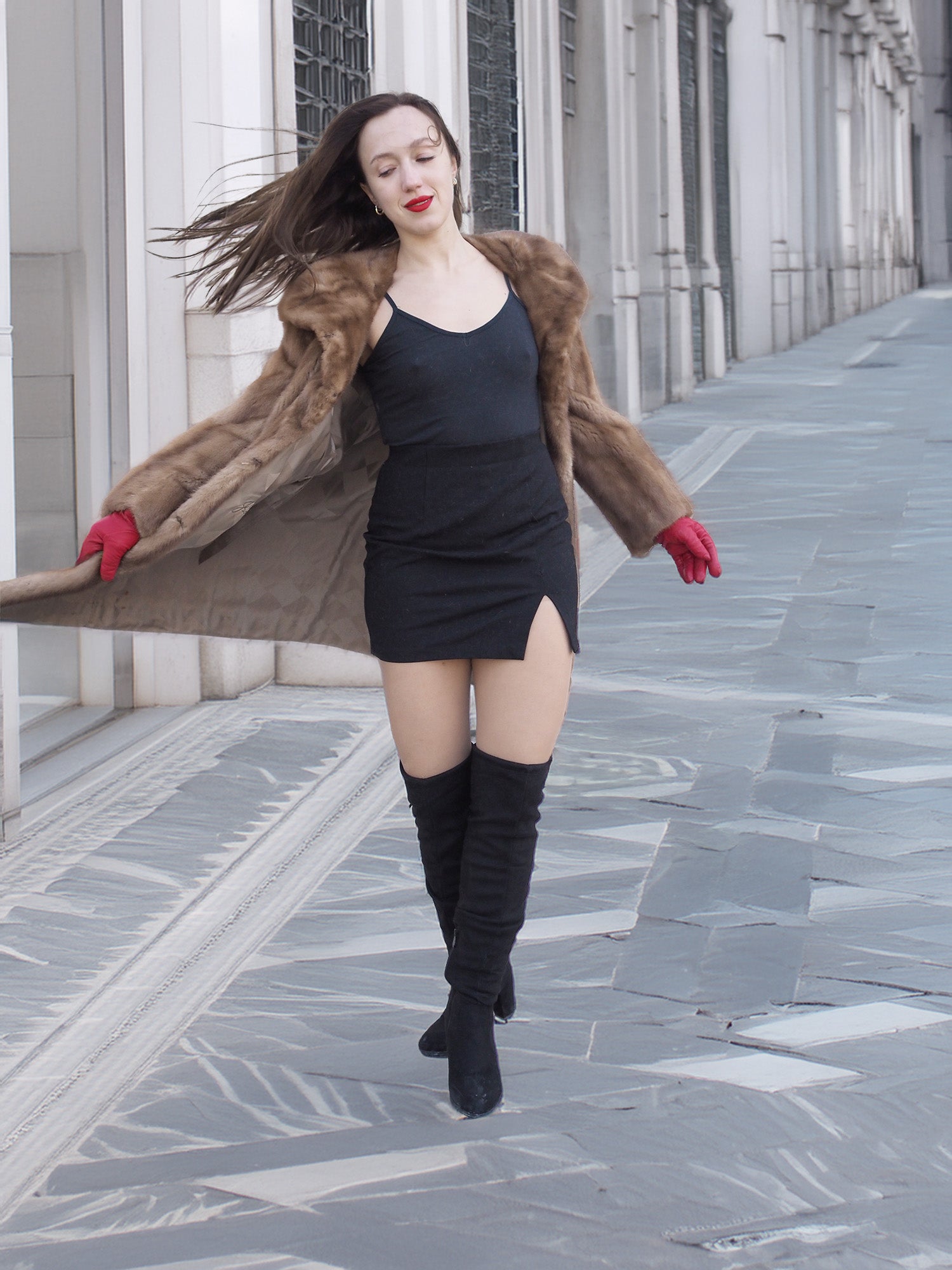 Model twirling in vintage pastel Canadian brown mink fur coat over black mini dress, highlighting movement and luxurious fur texture.