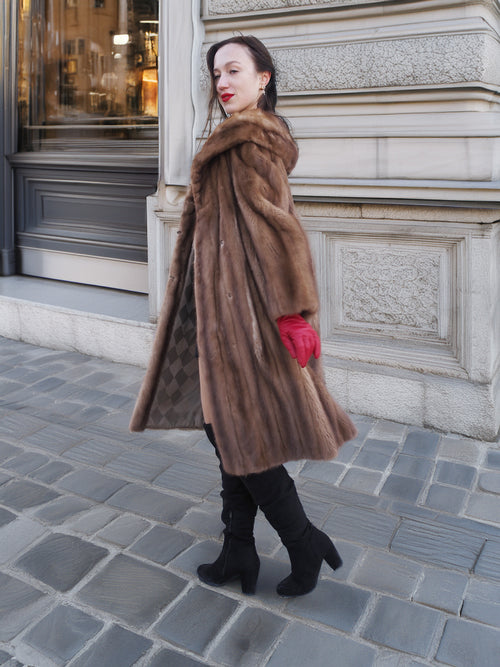 Model walking in vintage pastel Canadian brown mink fur coat with red gloves, showcasing elegant outerwear for cold-weather sophistication.