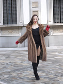 Model dancing in vintage pastel Canadian brown mink fur coat over black mini dress, perfect for stylish and playful winter fashion.