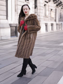 Model walking in vintage pastel Canadian brown mink fur coat, styled with red gloves and boots for refined winter outerwear fashion.