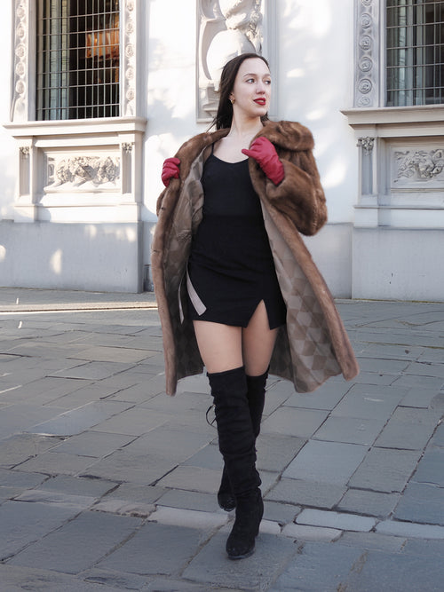 Model in motion wearing vintage pastel Canadian brown mink fur coat over black dress, ideal for bold and elegant winter fashion.