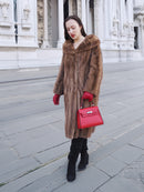 Model in vintage pastel Canadian brown mink fur coat holding red handbag, showcasing sophisticated outerwear for upscale winter wardrobes.