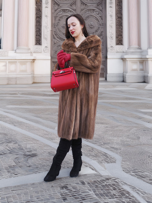 Model wearing vintage pastel Canadian brown mink fur coat with red gloves and handbag, showcasing elegant outerwear for formal occasions.