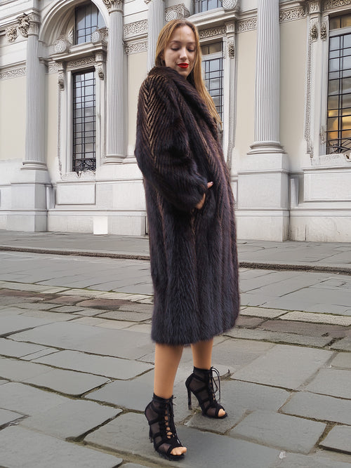 Woman in dark fur coat, posing on city street