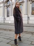 Woman in dark fur coat, posing on city street