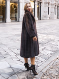 Woman in dark fur coat, smiling in urban setting