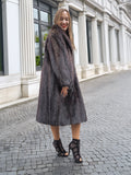 Woman in dark fur coat, city street background