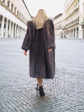 Back view of woman in dark fur coat, city street