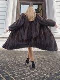 Back view of woman in dark fur coat, city setting