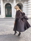 Woman in dark fur coat, walking in city setting