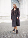 Woman in dark fur coat, poised in front of grand building