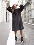 Woman in dark fur coat, city street background