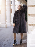 Elegant woman in luxurious dark fur coat, city backdrop