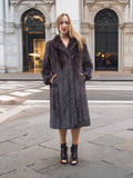 Fashionable woman in dark fur coat, urban crosswalk