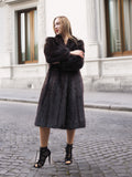 Woman in dark fur coat, standing on city street