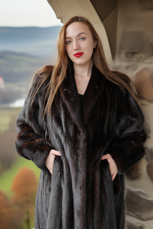 Woman wearing a dark fur coat with a scenic background