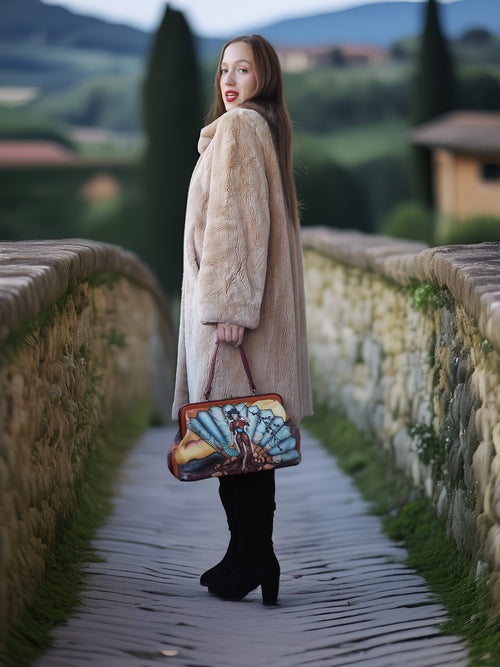 Woman in a fur coat holding a colorful handbag on a stone path with a scenic background