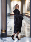 Woman wearing a black fur coat in an elegant interior setting