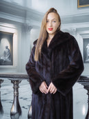 Woman wearing a dark fur coat in an elegant interior setting