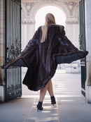 Person wearing a fur coat standing in an elegant architectural setting
