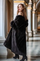 Woman wearing a black fur coat in an elegant interior setting