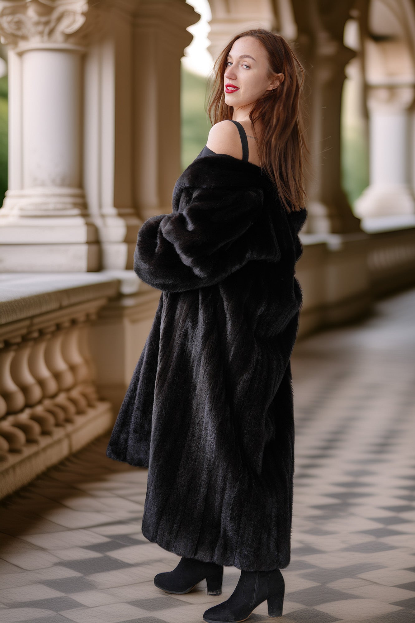 Woman wearing a long black fur coat in an elegant outdoor setting.