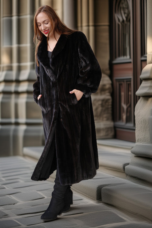 Woman wearing a black coat standing on a stone pavement with architectural background