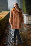 Warm caramel-brown mink fur coat with textured pile and broad, standing collar