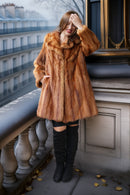 Caramel-brown mink fur coat with thick collar and relaxed fit, knee-length