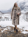 Model in fur coat walking through snowy landscape