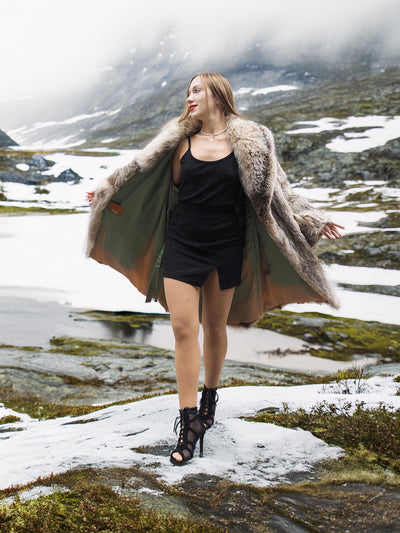 Model twirling in fur coat in snowy wilderness