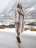 Model in plush fur coat by snowy lake