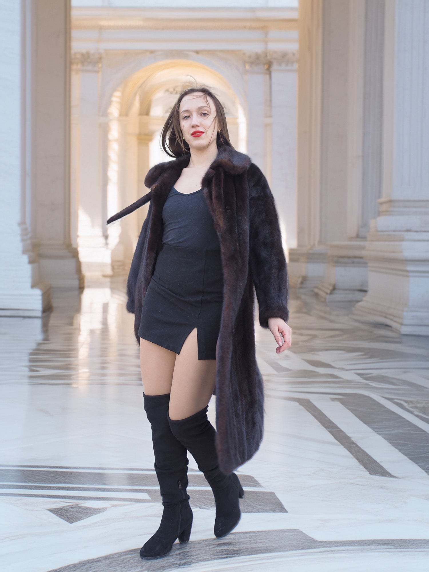 Model walking in La Galleria full-length mink fur coat, revealing satin lining and rich mahogany color for luxury winter fashion.