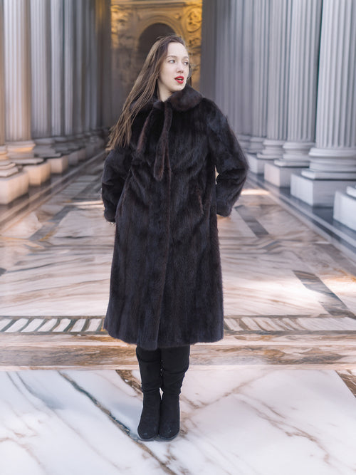 Elegant full-length La Galleria mink fur coat in mahogany, styled with tie-neck and black boots, ideal for luxury winter outerwear.
