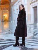La Galleria full-length mahogany mink fur coat with tie-neck detail, styled in a marble hallway for timeless winter elegance.